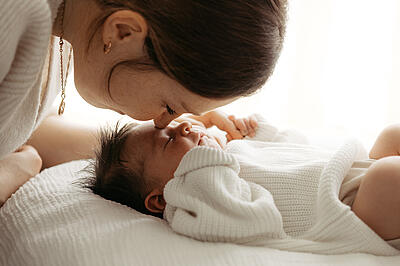 Klinikreportage am St. Josefskrankenhaus Freiburg, Mutter küsst Baby auf Stirn, Marina Müller Fotografie